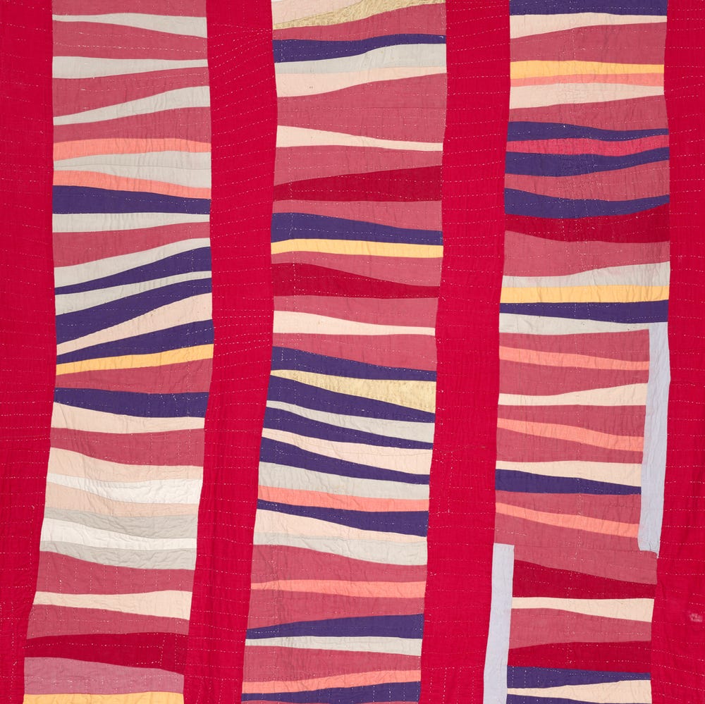 Geometric quilt in red, blue, orange, yellow, pink, and white