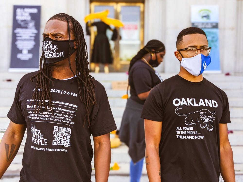 two men wearing Black Power T-shirts