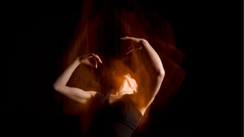 Photograph of person dancing in low light
