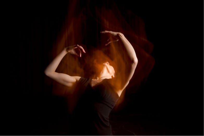 Photograph of person dancing in low light