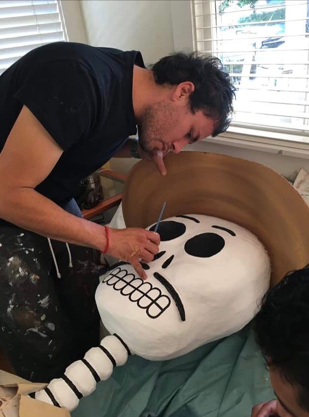 Fernando Escaritz painting a skeleton sculpture