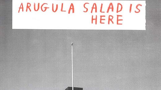 Building with a spire in bottom center with text in top center saying "Arugula salad is here"