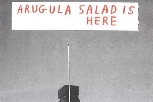 Building with a spire in bottom center with text in top center saying "Arugula salad is here"