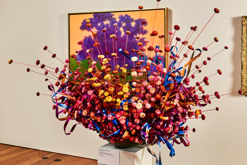 Purple, yellow, blue, and white flowers displayed in a gallery