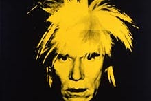 Andy Warhol's face in with hair sticking up in bright yellow against a black background
