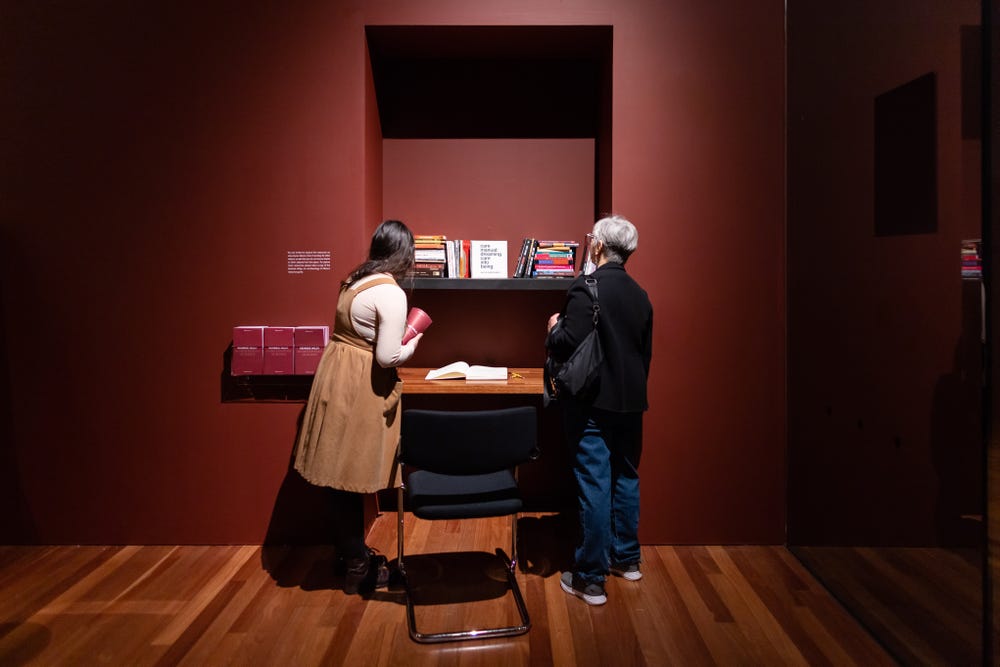 Visitors looking at books in Kehinde Wiley exhibition respite room