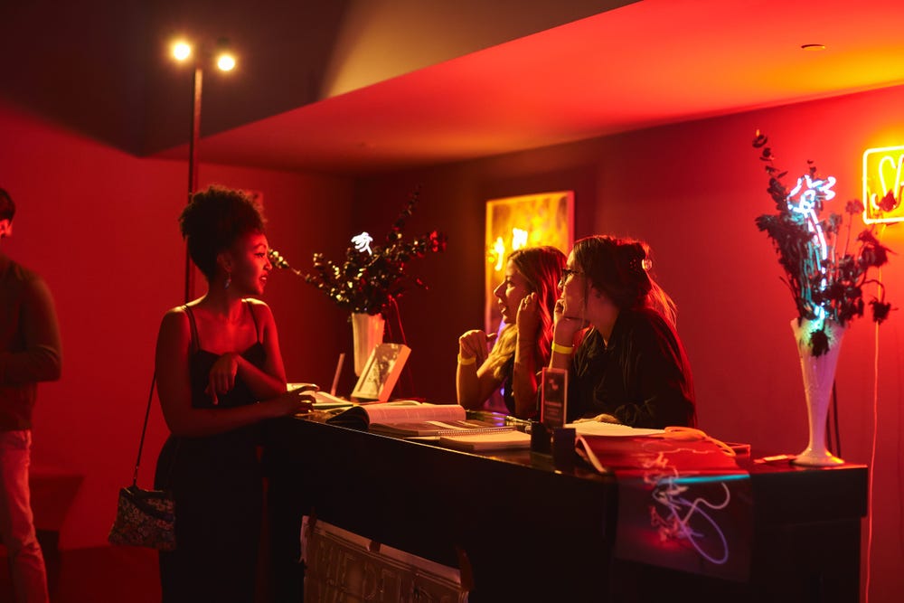 People at a bar counter talking to one another in a decorated room
