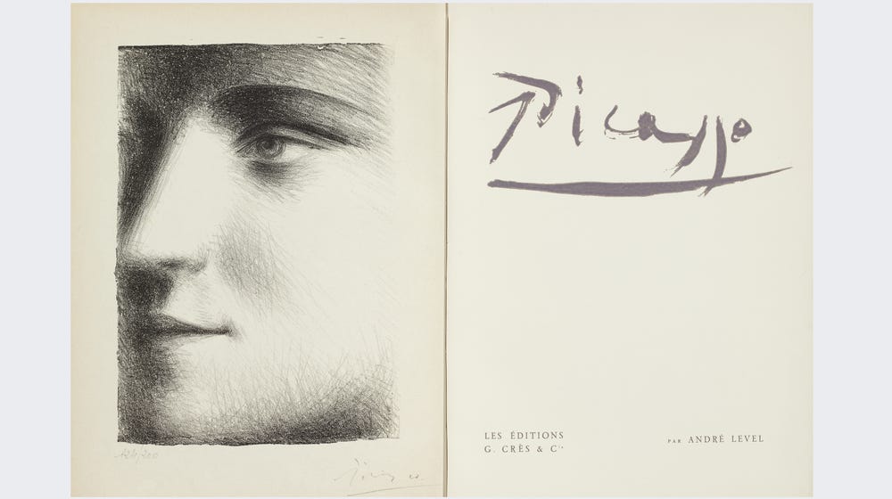 Open pages of a book with a drawing of a face on the left side and “Picasso” on the right