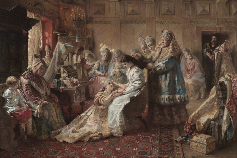 a woman on her wedding day, surrounded by other women, getting her hair done
