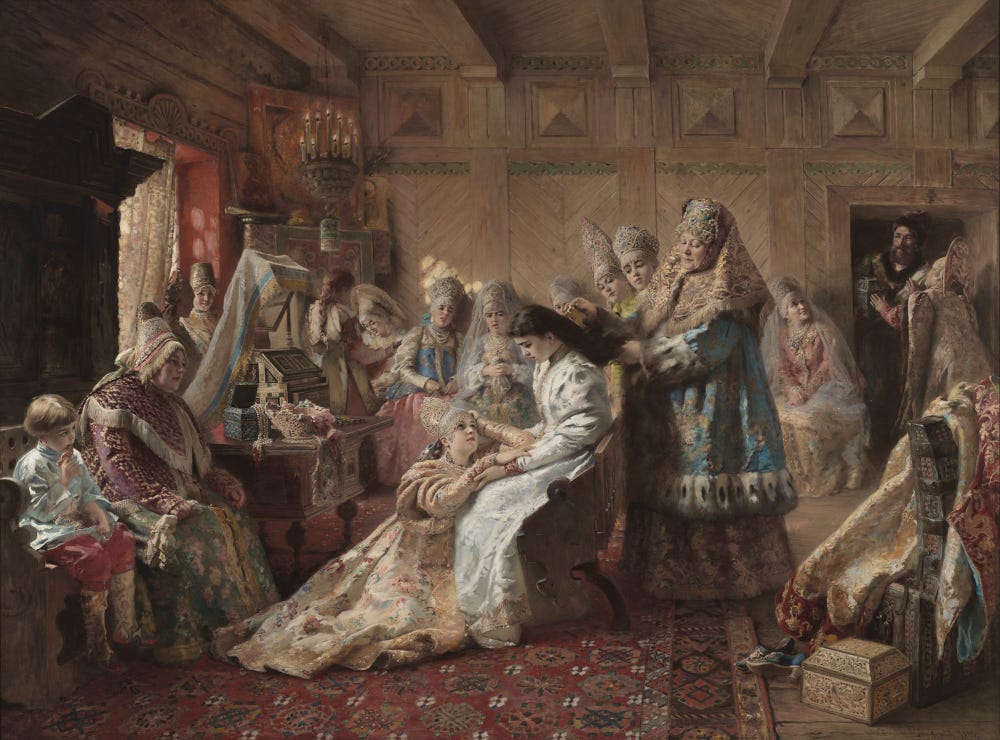 a woman on her wedding day, surrounded by other women, getting her hair done