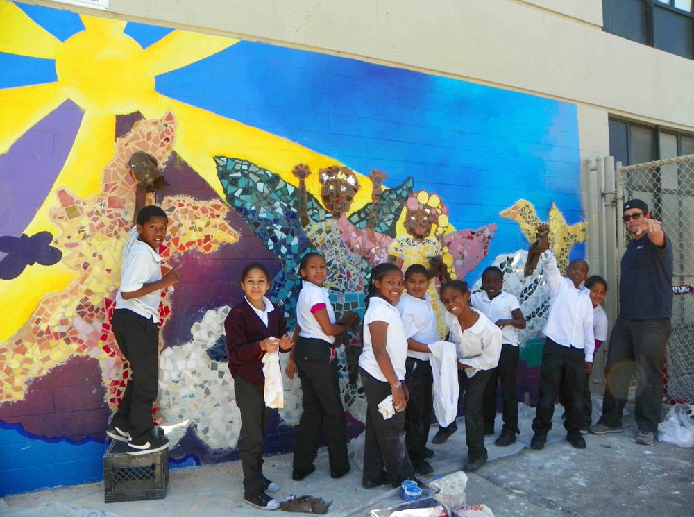 group of kids in front of their mural