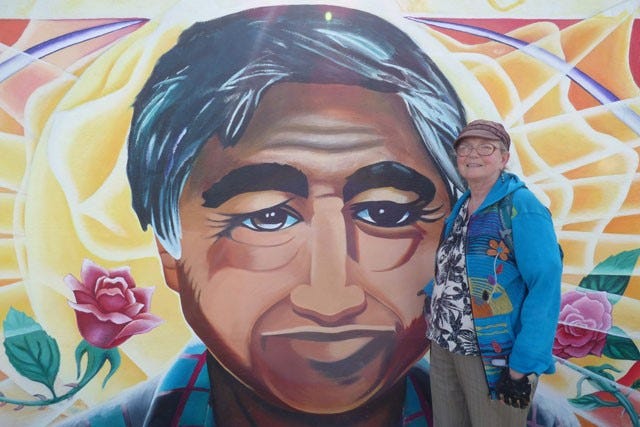 woman standing next to a mural of a face