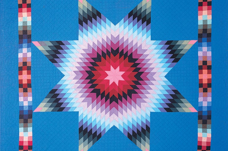 Blue quilt with multicolored star pattern.