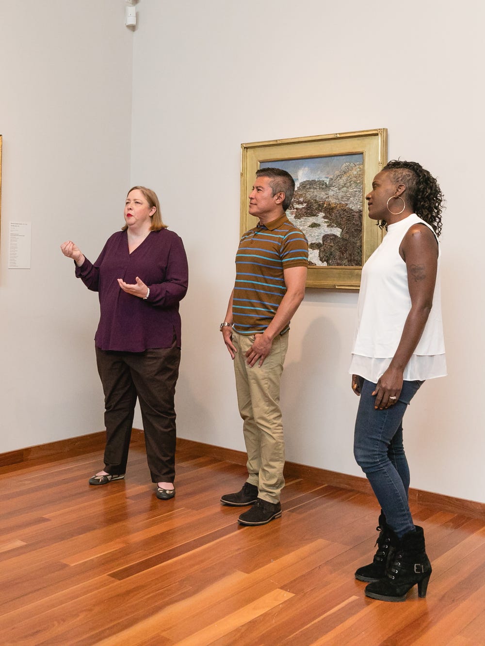 Five people looking at and discussing art in a gallery
