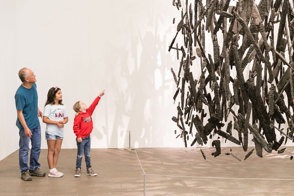 Parent and children looking at art