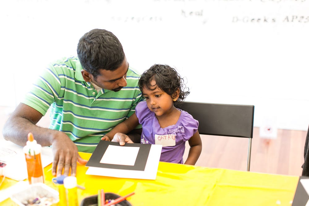 a father and daughter doing an art activity