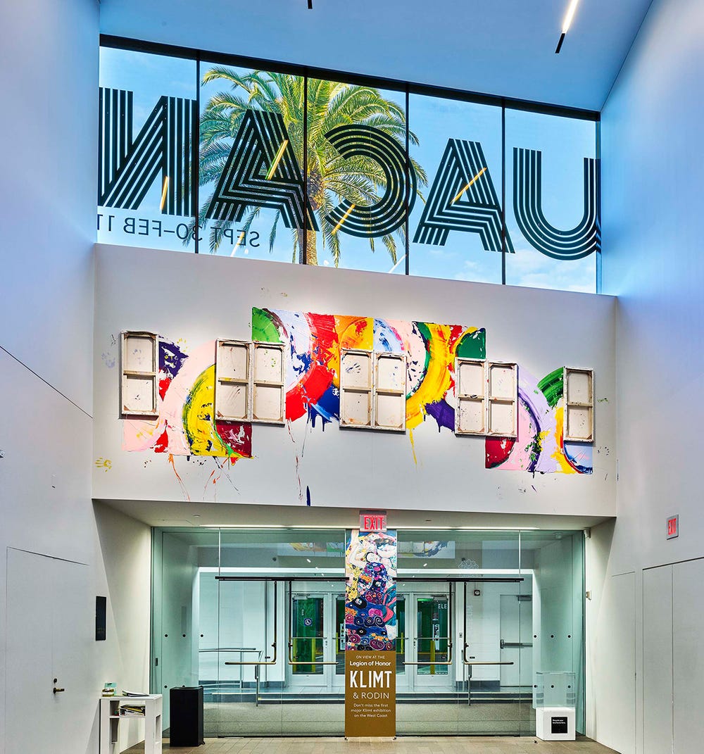 installation view of an artwork with colorful paint and canvases facing the wall