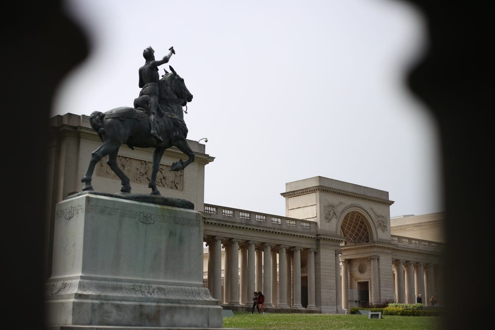 a statue of a woman on a horse in front of the Legion of Honor museum