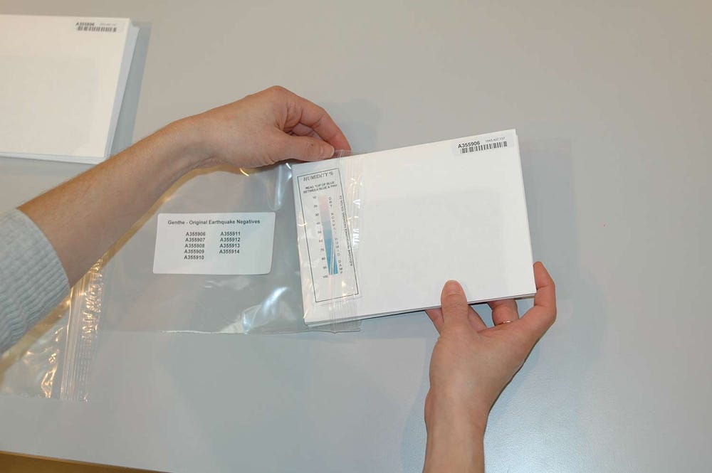 hands sliding paper into a plastic bag