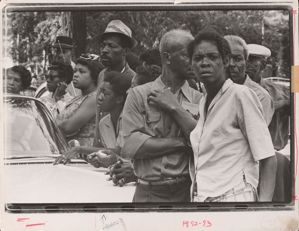 Group of Black people watching the funeral procession