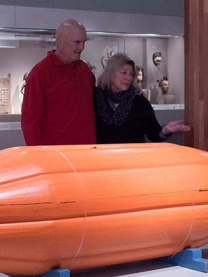 People looking at Seth Kwei's coffin in the shape of a cocoa pod