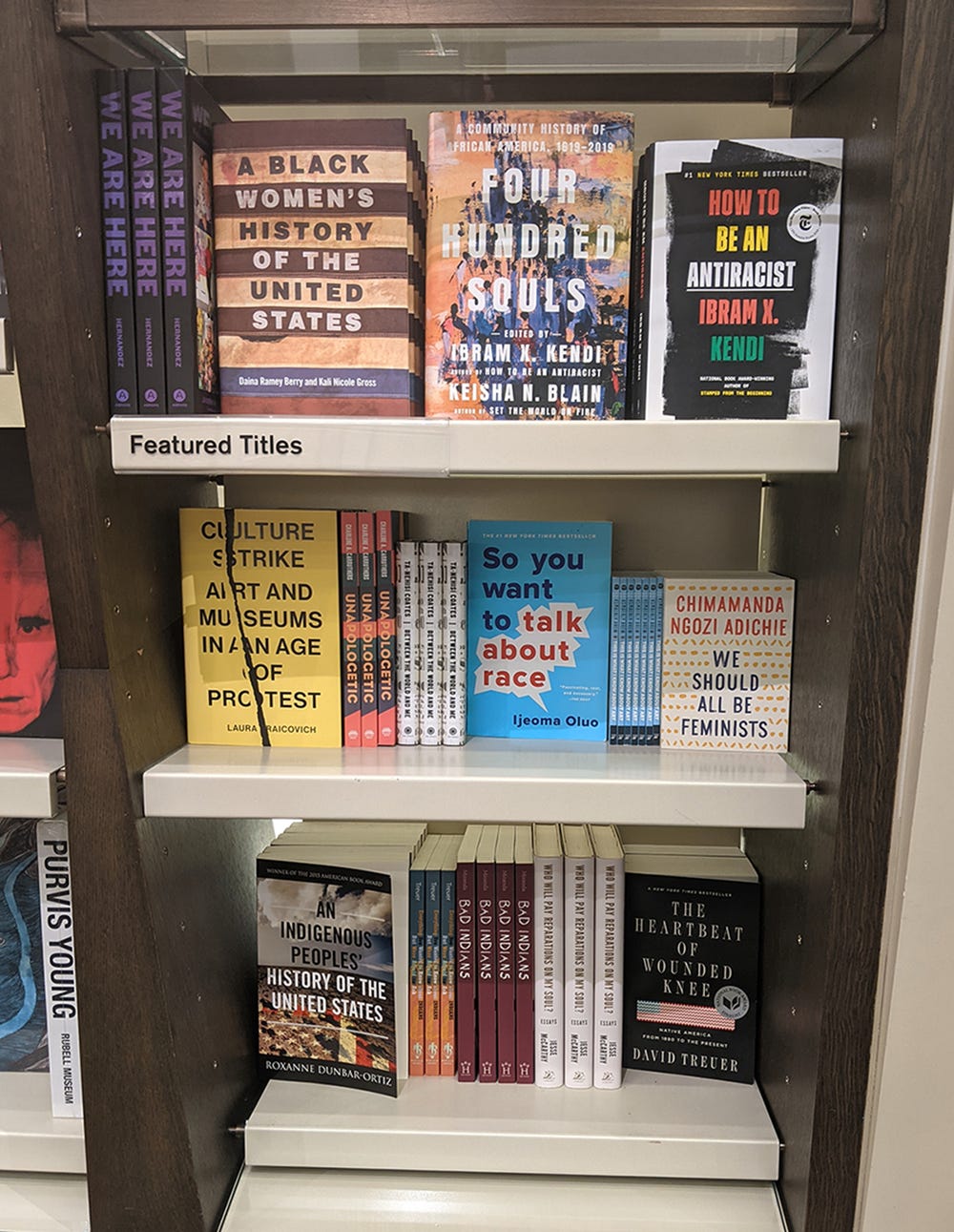three shelves of books featuring titles supporting diversity and inclusion