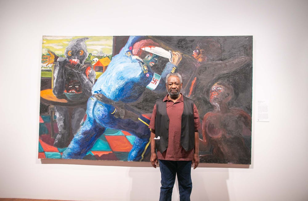 Artist Mike Henderson in front of his painting Non-Violence