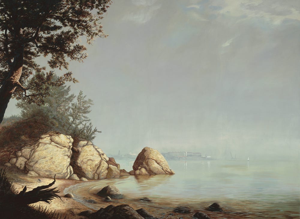 beach landscape with rocks in left foreground and prison in the background