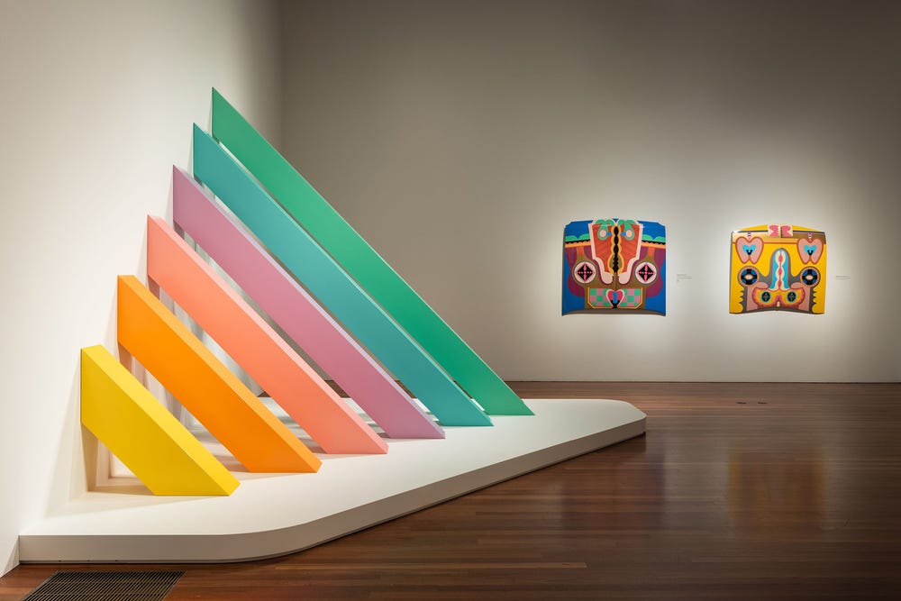 gallery at the de Young museum with rainbow painted plywood artwork and colorfully painted car hood artwork