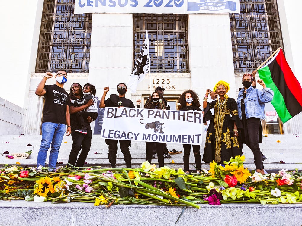 group holding a "Black Panther Legacy Monument" banner