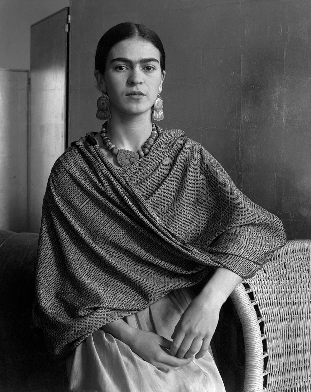 black and white portrait of Frida Kahlo with large jewelry and a shawl