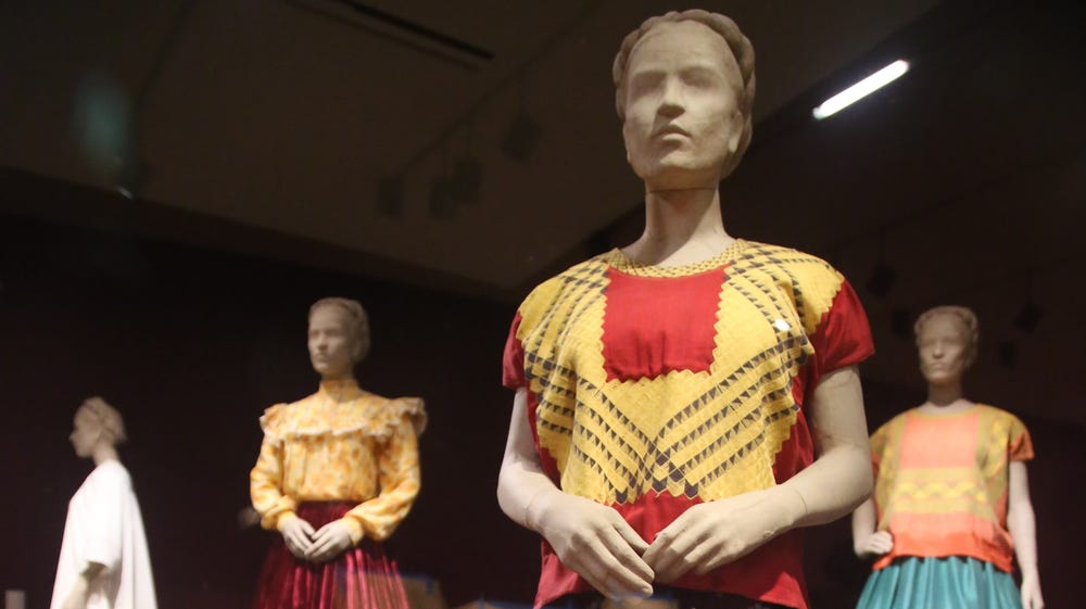 mannequins wearing blouses and floor-length skirts