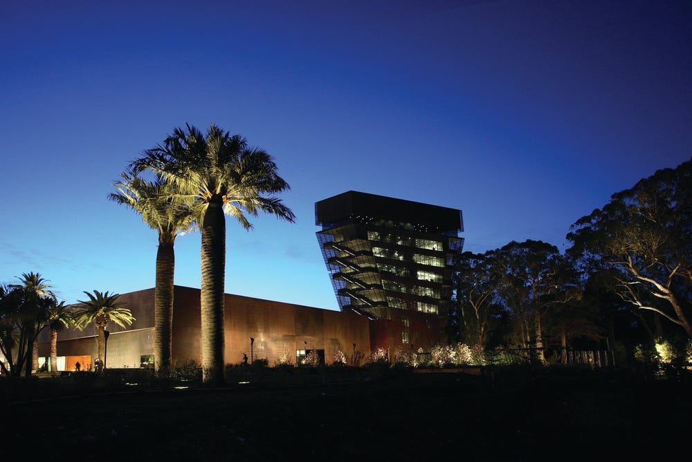 Photograph of exterior of de Young museum at night.