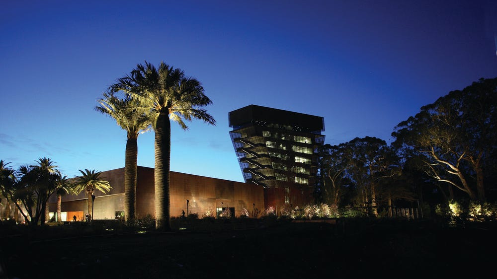 Photograph of exterior of de Young museum at night.