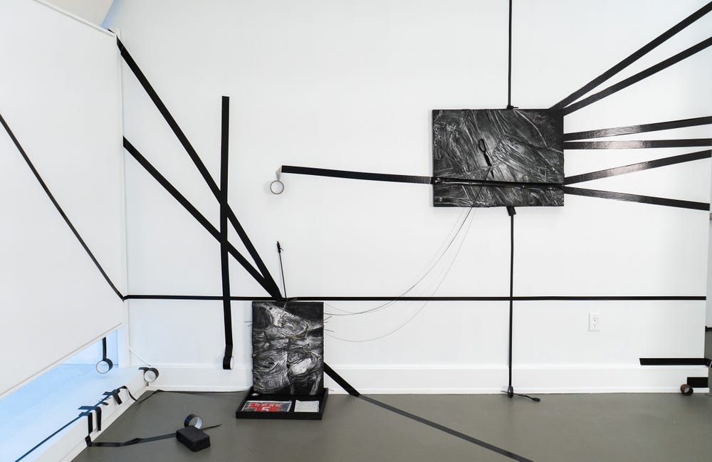 white room with black tape strips applied on walls