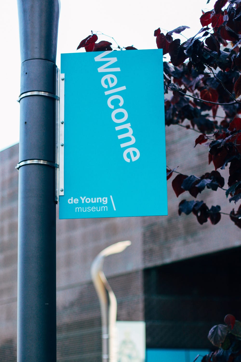 teal sign that reads "Welcome" and "de Young museum"