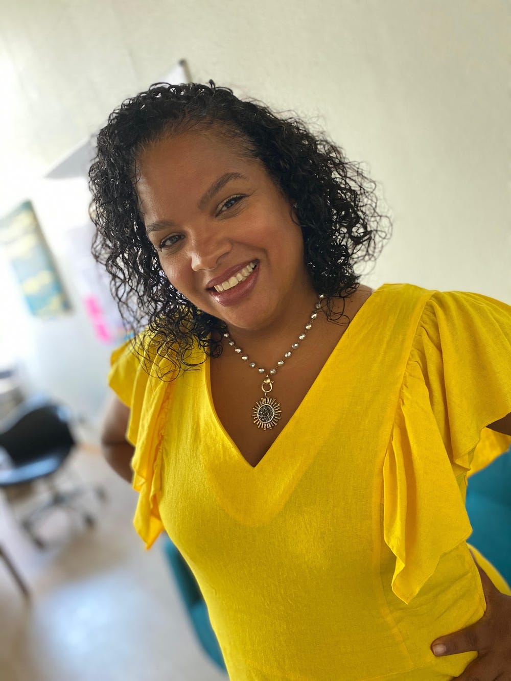 Black woman in a yellow shirt smiling
