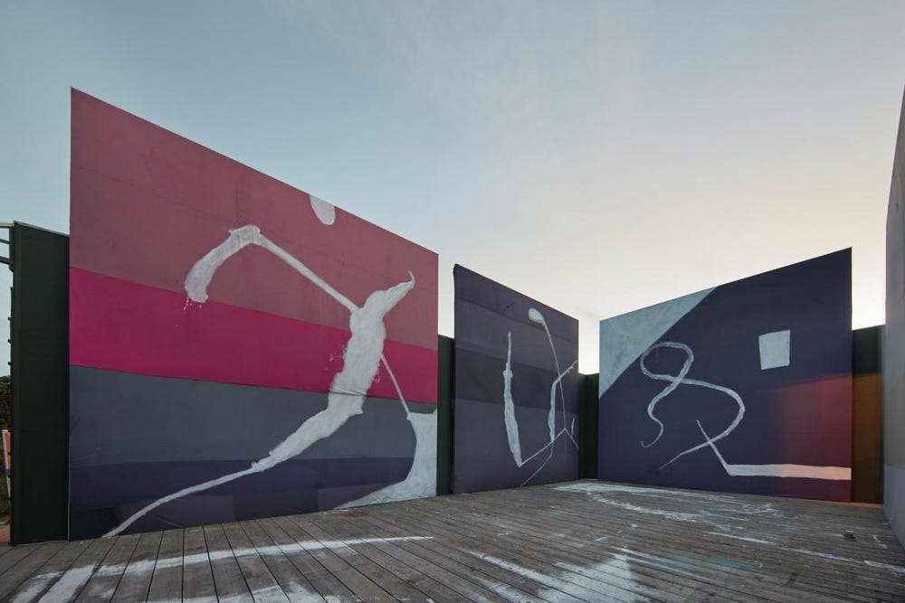 Photograph of large-scale colorful paintings displayed outdoors.