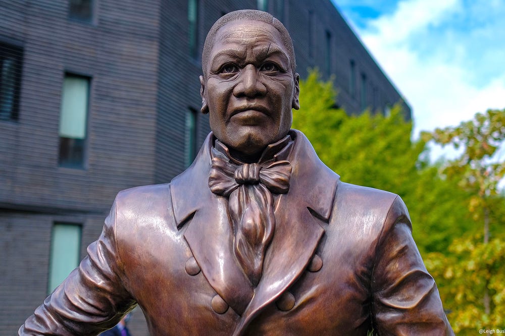 close up of a bronze statue of a man in a suit