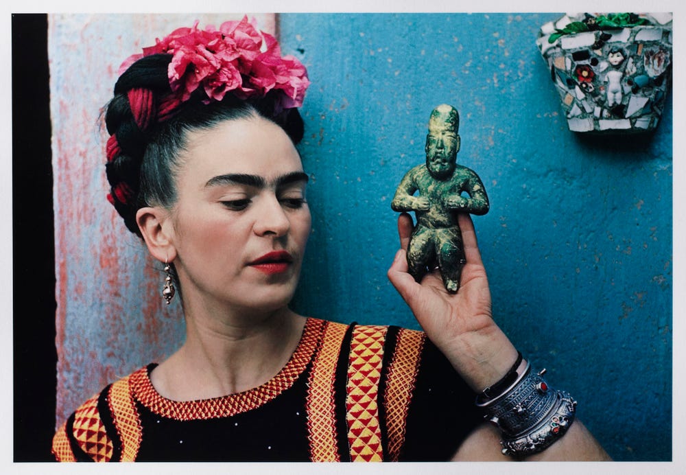 Frida Kahlo holding a small Olmeca figurine