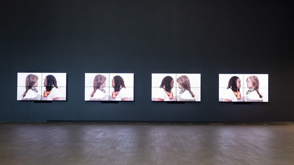 four screens showing a Black woman interacting with robot bust styled to resemble her