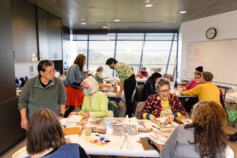 Older adults in a de Young classroom making art