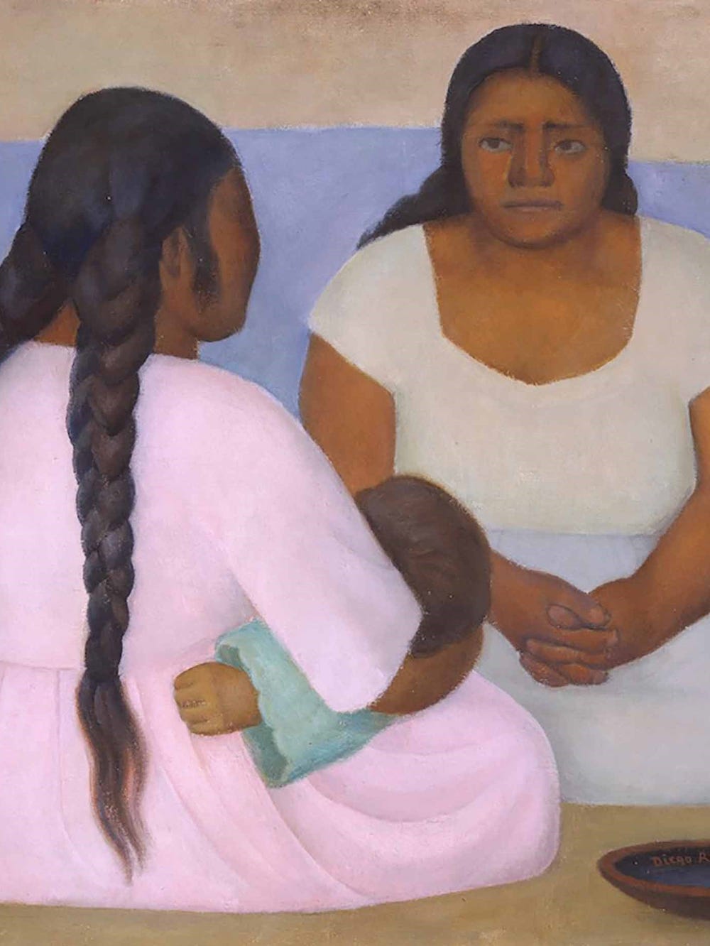 two women with braids sitting on the floor, one holding a child