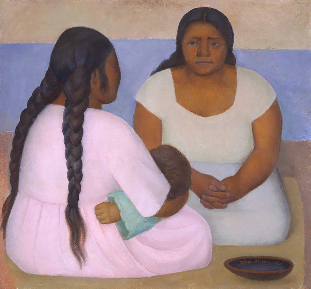 two women with braids sitting on the floor, one holding a child