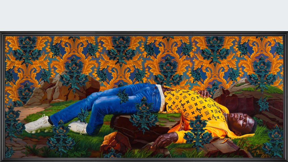 Man with his eyes closed laying on a grassy ground, in front of a colorful wallpaper backdrop