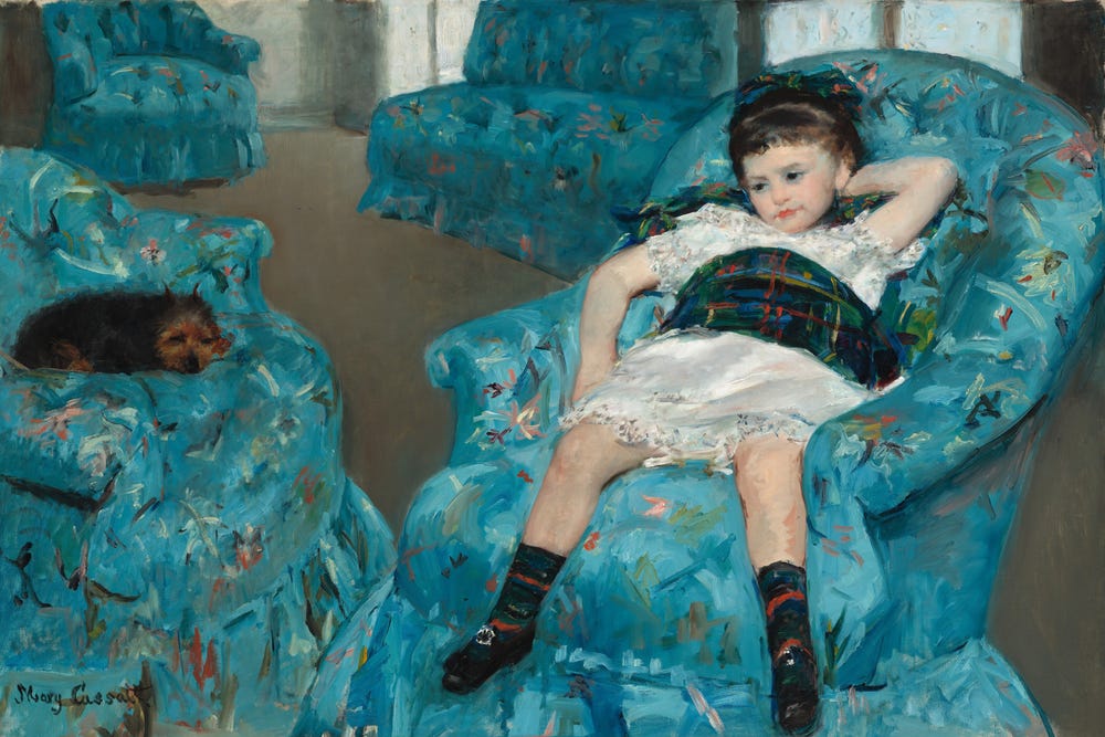 Little girl laying in a blue armchair
