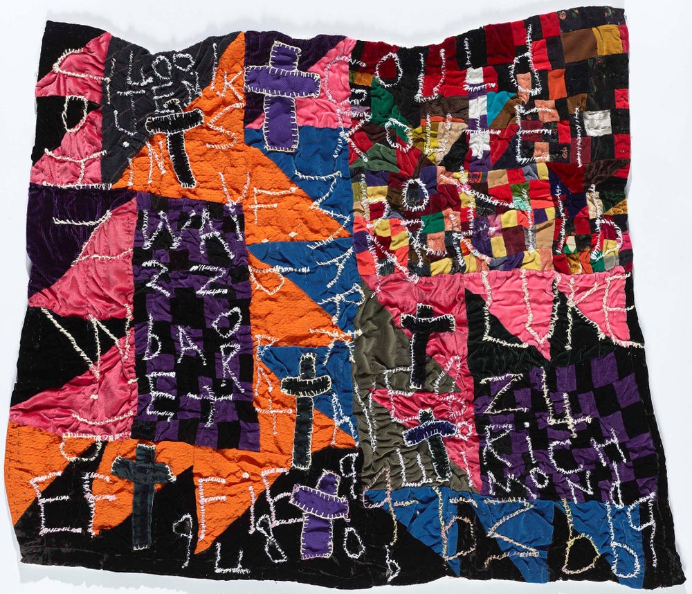 brightly colored quilt with white letters and symbols