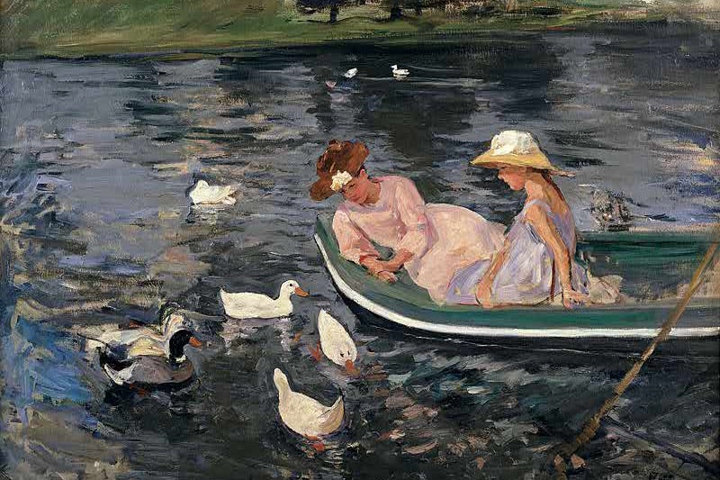Two women in a boat on water looking at ducks