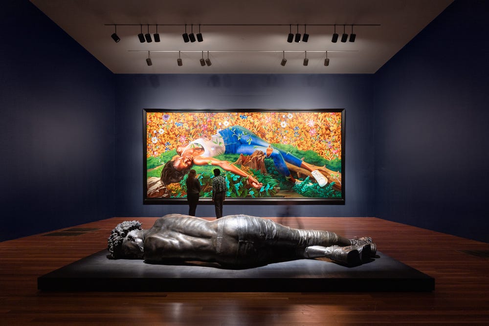People in a de Young museum gallery with works by Kehinde Wiley