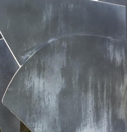 detail of metal sculpture with grayish paint